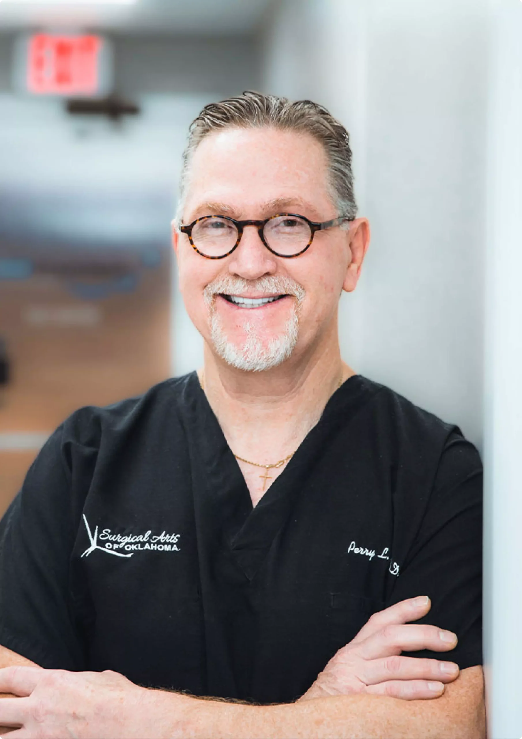 Dr. Perry Brooks smiling in professional black scrubs at Surgical Arts of Oklahoma